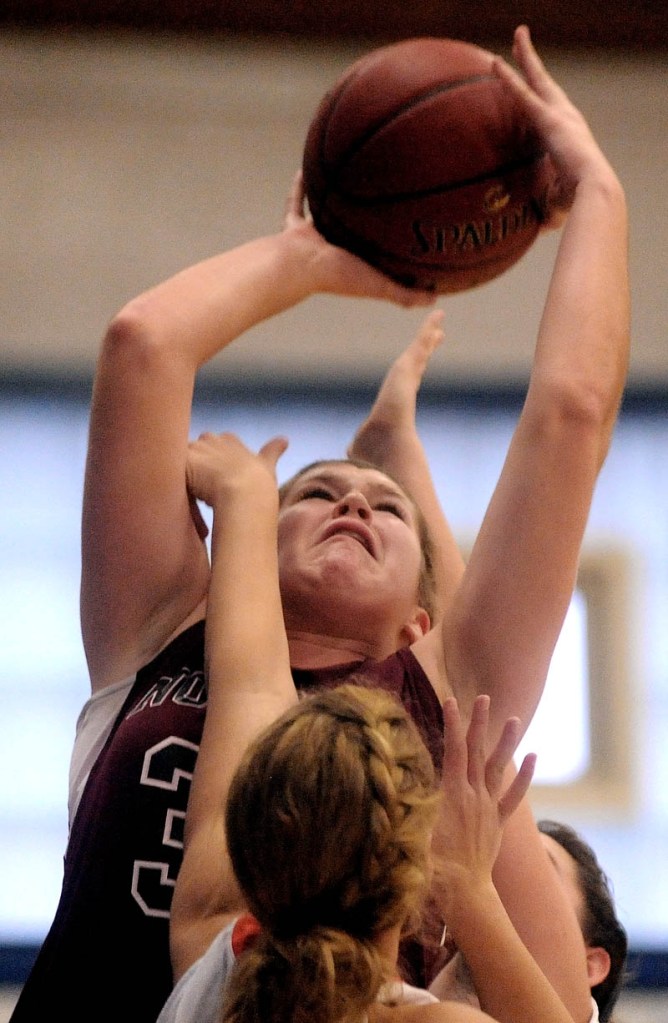 Staff photo by Michael G. Seamans Nokomis High School's Anna Mckenzie, 30, shoots over a Skowhegan High School defender in the second half of girls basketball action in the Bulldog Classic at Lawrence High School in Fairfield Saturday.