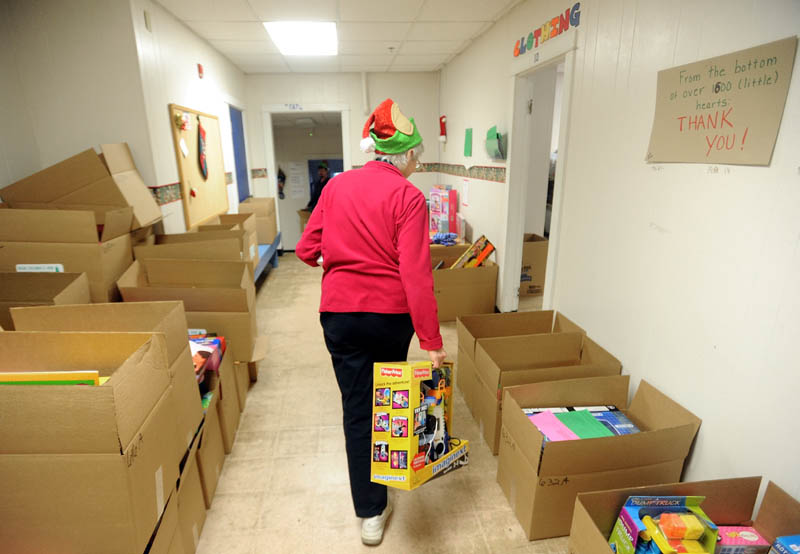 Peggy Walker, of the Waterville Housing Authority, packs gift boxes to be distributed to disadvantaged children in the area for the holidays, at the Maine Children's Home for Little Wanderers in Waterville, on Thursday.