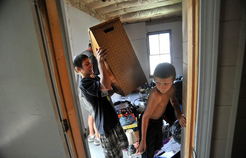 Rusty Wing, 14, left, and his step-brother, Dakota LaBrie,11, organize donated goods from charities at their new apartment on King Street in Waterville.