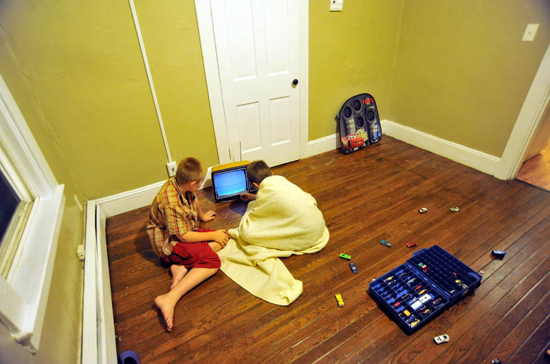 Raymond and Dakota LaBrie sit on the floor and try to get a donated, 12-inch, black-and-white television to work, on their first night in the family's new apartment on King Street in Waterville. According to their mother, Janet White, this is the first time the children have had their own rooms to sleep in, a positive side to the family's displacement by a fire that destroyed their Waterville home.