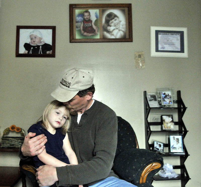 Jeff White gives his step-daughter, Savannah LaBrie, 4, a hug at the family's apartment on King Street in Waterville.