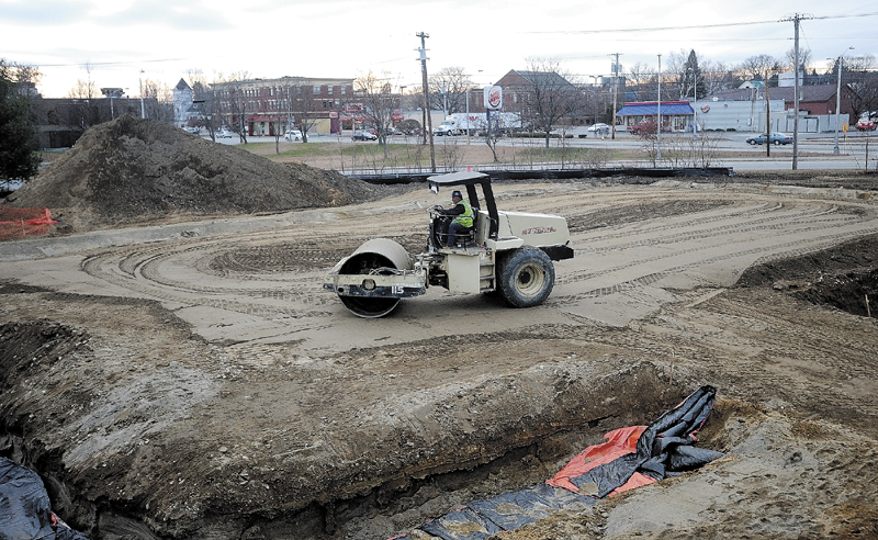 Construction workers level the ground of the new Waterville police station site for a foundation, at Colby Circle in Waterville, on Tuesday.