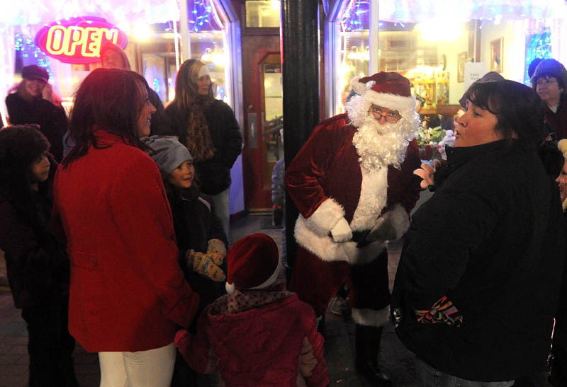 Santa Claus talks with parade-goers at the Holiday Stroll parade, on Water Street in downtown Skowhegan, on Friday.