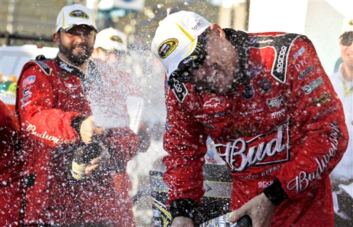 Kevin Harvick laughs as he tries to avoid being sprayed while celebrating in victory lane with his pit crew after his win at the NASCAR Sprint Cup Series auto race win at Phoenix International Raceway, Sunday, Nov. 11, 2012, in Avondale, Ariz. (AP Photo/Ross D. Franklin)