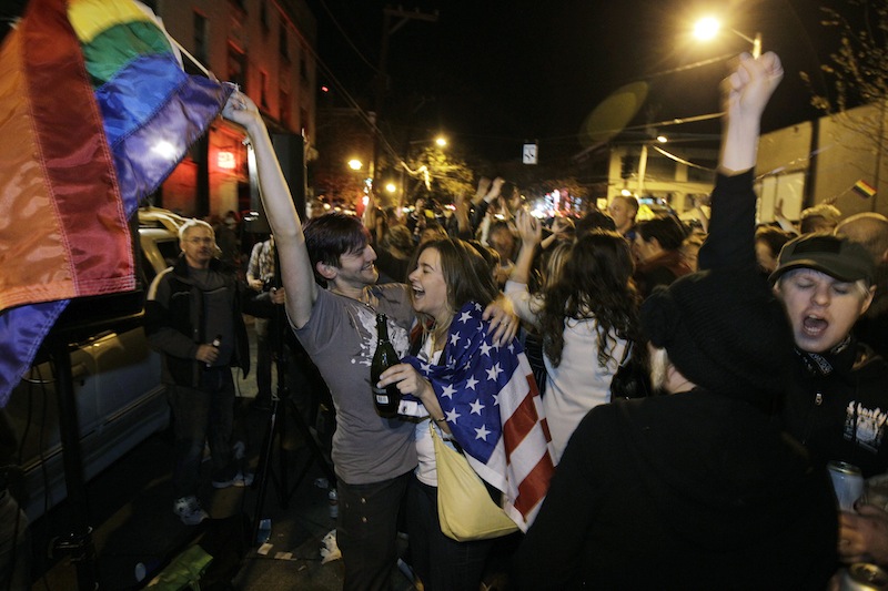 Revelers display U.S. and gay pride flags as they celebrate early election returns favoring Washington state Referendum 74, which would legalize gay marriage, during a large impromptu street gathering in Seattle's Capitol Hill neighborhood, in the early hours of Wednesday, Nov. 7, 2012. The re-election of President Barack Obama and Referendum 74 drew the most supporters to the streets. (AP Photo/Ted S. Warren)