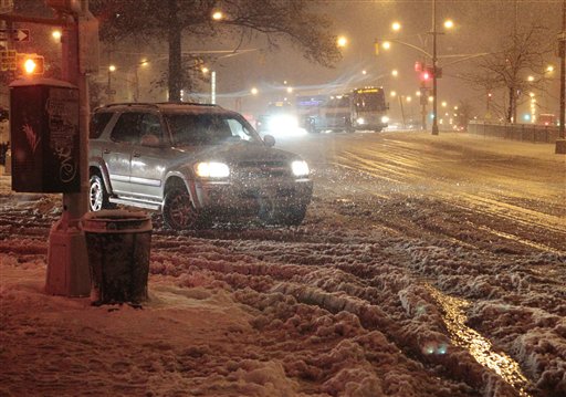 Cars navigate Queens Boulevard during a snow storm on Wednesday in the Queens borough of New York.