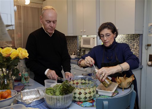 Karen Nelson, and her house guest Gregory Downer prepare dinner in her upper west side apartment in New York on Thursday evenin. Like herself, her neighbors have taken in dozens of "refugees," people who have fled their cold, dark homes in search of a roof, food, a hot shower and juice for their cell phones, iPads and laptops.