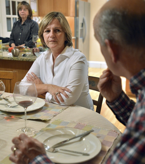 In this photo taken Friday, Nov. 16, 2012, Anne Brennan, center, of Hingham Mass., listens to her sister, Linda Marshall, rear, and brother-in-law Steve Marshall, right, discuss the recent presidential election as the family gathers for dinner in Hingham and where politics are a frequent, and divisive topic of conversation. (AP Photo/Josh Reynolds)