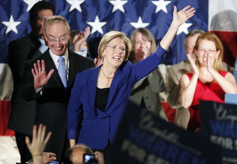 Democrat Elizabeth Warren, center, waves to the crowd with her husband Bruce Mann, left, during an election night rally at the Fairmont Copley Plaza hotel in Boston after Warren defeated incumbent GOP Sen. Scott Brown in the Massachusetts Senate race, Tuesday, Nov. 6, 2012. (AP Photo/Michael Dwyer)