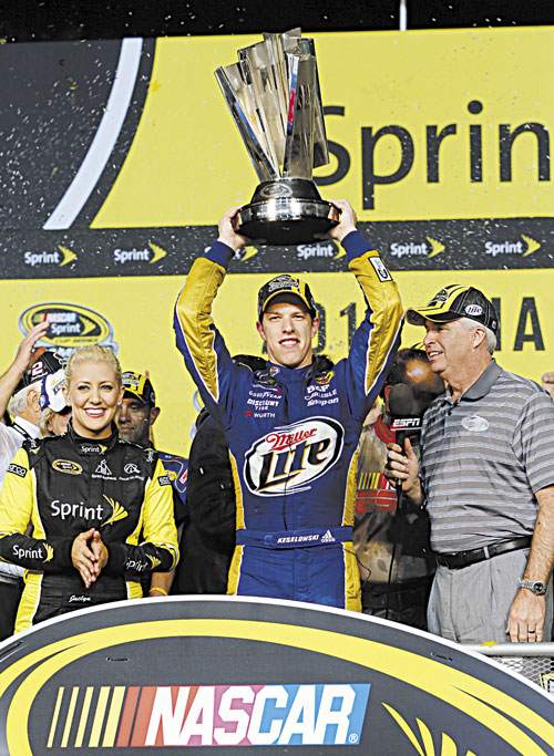 CHAMPION: Brad Keselowski holds up his trophy after winning the NASCAR Sprint Cup Series championship following Sunday’s race at Homestead-Miami Speedway in Homestead, Fla. Keselowski clinched the title after fellow contender Jimmie Johnson pulled out of the season finale because of a parts failure. Jeff Gordon won the race.