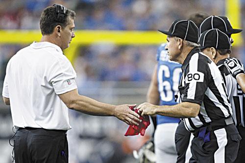 COSTLY ERROR: Field judge Greg Gautreaux (80) hands the red challenge flag back to Detroit Lions head coach Jim Schwartz after the coach mistakingly challenged a scoring play against the Houston Texans on Thursday in Detroit.