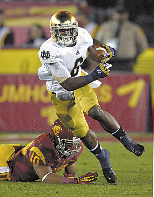 HERE I COME: Notre Dame running back Theo Riddick, left, runs the ball as Southern California linebacker Hayes Pullard tries to tackle him during the first half of the Fighting Irish’s 22-13 win Saturday in Los Angeles.