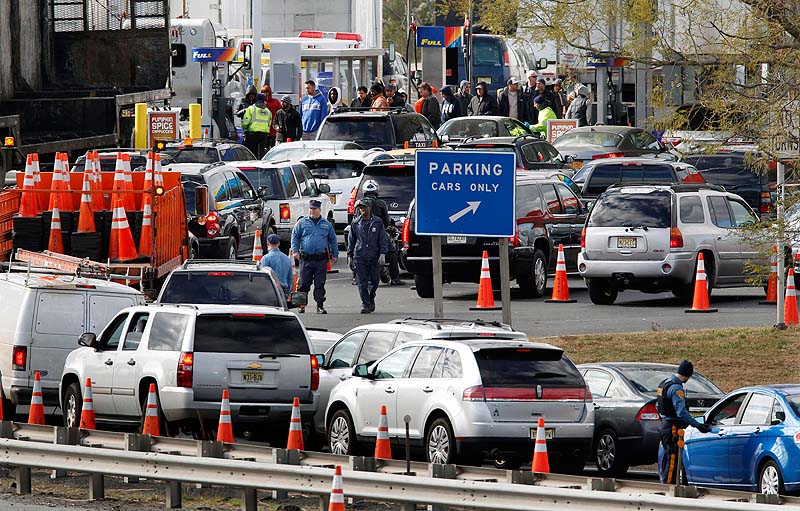 New Jersey state troopers keep order as motorists line up to purchase gasoline at the Thomas A. Edison service area on the New Jersey Turnpike Saturday. From storm-scarred New Jersey to parts of Connecticut, a widespread lack of gasoline added to the frustration since Superstorm Sandy passed through the area. Gas rationing was to starting at noon Saturday in northern New Jersey, where drivers will be allowed to buy it only every other day.