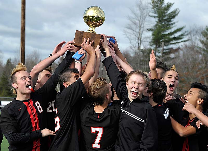 Scarborough holds the Gold Ball after winning the state Class A boys' soccer championship Saturday at Hampden Academy. Scarborough beat Mt. Ararat, 4-0.