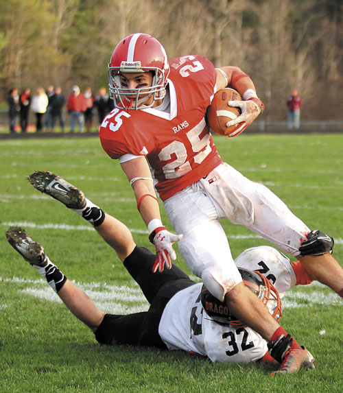 TRYING TO GET BY: Cony High School’s Tayler Carrier looks upfield while trying to get around an arm tackle by Brunswick High School’s Jared Jensen in the first half of a Pine Tree Conference Class A seminfinal game Saturday in Augusta. Cony won 21-20 and will take on Lawrence for the conference title Saturday in Fairfield.