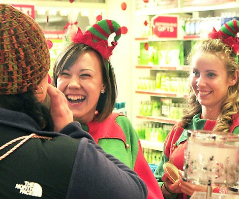 Customer Kari Turgeon, left, smells a candle as she is waited on by a pair of Bath & Bodyworks clerks dressed as elves at at 5:47 Friday morning in the Marketplace at Augusta. Alexis Saucier, center, said that she was Hermie the elf, while co-worker Stephanie Smith's nametag read Buddy.