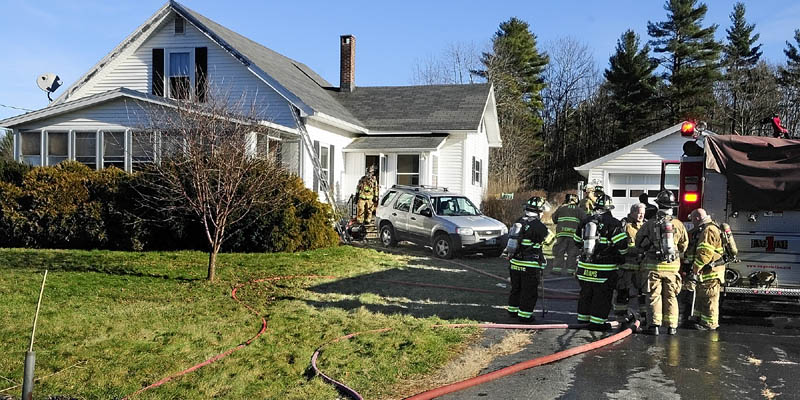 Firefighters work at 283 Spring Road after extinguishing a fire there this afternoon.