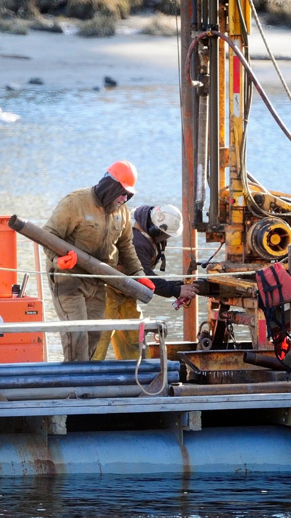 Workers drill from a barge on Thursday morning in the middle of the Kennebec River, in downtown Augusta.