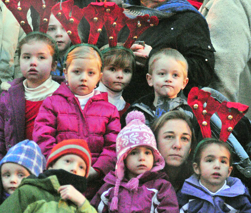 Spectators watch dancers perform in the middle of Water Street, in front of the Olde Federal Building, before the annual tree lighting on Saturday in downtown Augusta. The children wearing antlers were waiting their turn to perform.