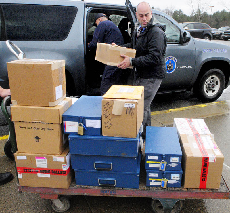 Maine State Police Trooper Jack Dow, left, reaches back into his vehicle for another ballot box as State Police Sgt. Mike Zabursky loads a cart on Tuesday afternoon, outside the Department of Public Safety headquarters on Commerce Drive in Augusta. Dow had collected ballot boxes in Gray, North Yarmouth and Pownal for recounts scheduled to begin Wednesday morning.