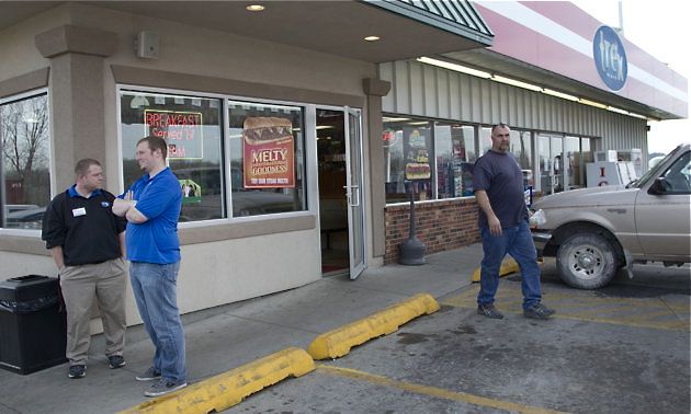 An unidentified customer walks out of the Trex Mart convenience store, right, while manager Chris Nauerz, left, and son of the owner Baron Hartell stand outside, in Dearborn, Mo., on Thursday.