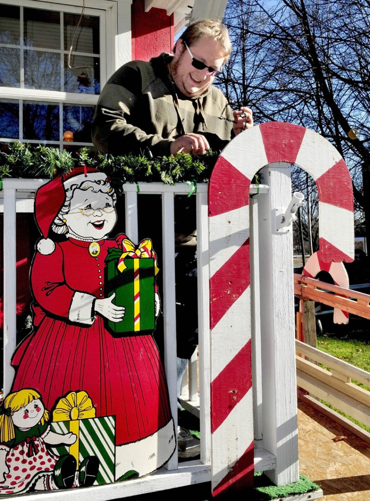 Alex Small, coordinator for the Parade of Lights, decorates Kringleville in Waterville on Sunday. The annual holiday season kickoff parade event is this Friday at 6 p.m., beginning at the American Legion and heading toward downtown Waterville.
