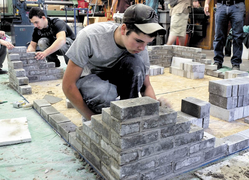 Carrabec High School industrial technology class students Ken White, left, and Francis Musotic build a brick structure on Wednesday. The students are learning skills that will be used when brick benches are made for the new front portico structure.