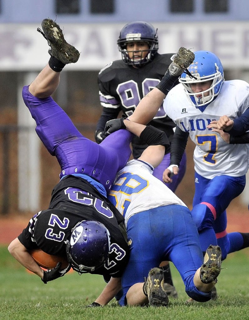 UP AND OVER: Waterville’s Jordan DeRosby (23) gets flipped head over heels by Belfast defender Carl Dodge (28) on the opening kickoff during the Panthers’ 31-14 win over Belfast in the Pine Tree Conference Class B semifinals Saturday in Waterville.