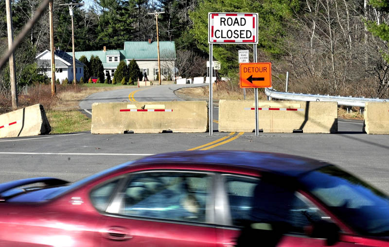 Traffic passes the Whittier Road in Farmington on Wednesday. The road that has been blocked off due to erosion of soil between the roadway and Sandy River.