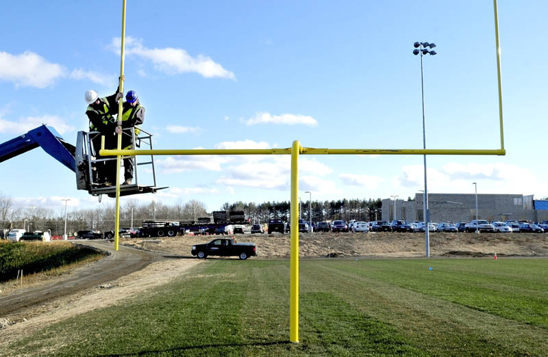David Durrell, left, and Kermit Clements, of E.L. Vining & Son, work on one of the goalposts at the new football field, at Mt. Blue High School in Farmington, on Monday. Work on the school expansion project and athletic fields is expected to be finished next year.