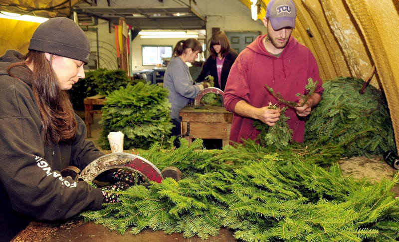 Central Maine Wreath Co. workers are busy making holiday wreaths, garlands, canes, crosses and hearts at the Skowhegan business on Thursday. Owner Tom McCarthy said he expects to make 20,000 wreaths this season. From left are Kristie Meader, Retta Giguere, Ida Beane and Gary Meader.