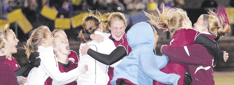CHAMPIONS: Richmond’s Brianna Snedecker, center, is mobbed by her teammates after her penalty kick helped seal a victory over Washburn as the Bobcats won the Class D state championship on Saturday night at Hampden Academy.