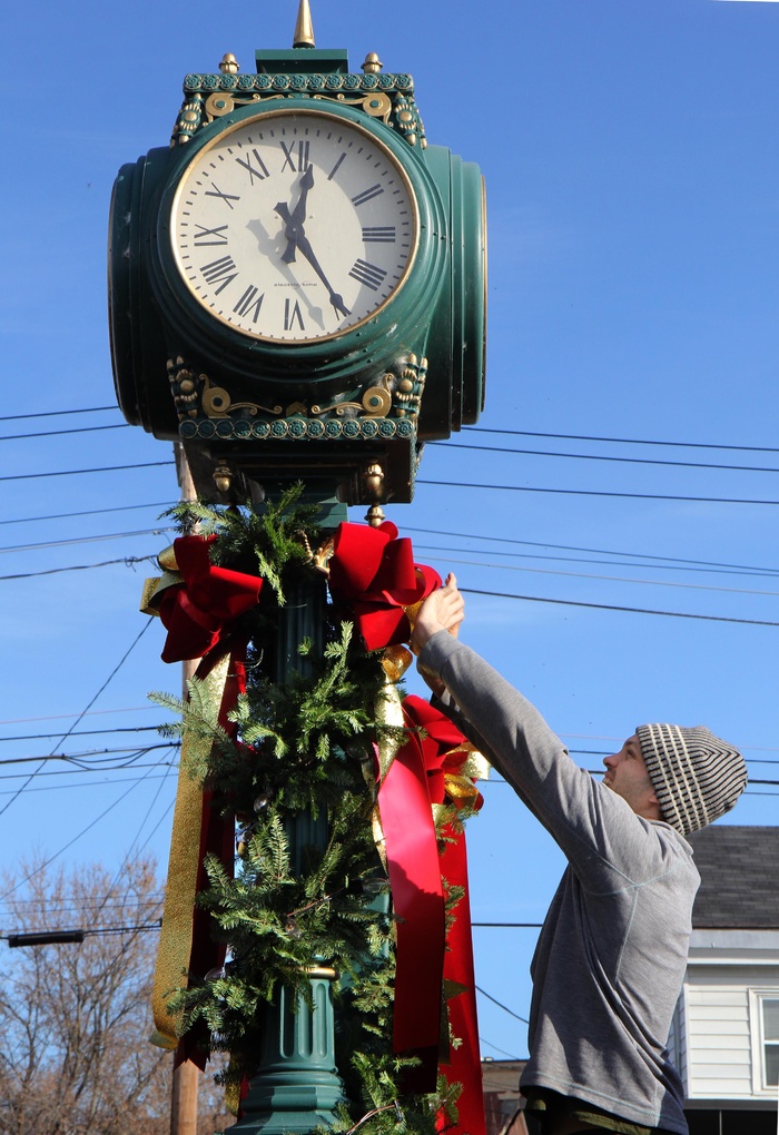 Matt Hopkins of Hopkins Flowers in Manchester decorates a clock at the Kennebec Savings Bank branch on Main Street in Waterville on Friday. Hopkins and he and several other employees of the flower company have been decorating Kennebec Savings Bank branches throughout central Maine. "Yesterday we were in Augusta and the day before, Gardiner. We usually start decorating around Thanksgiving," Hopkins said.