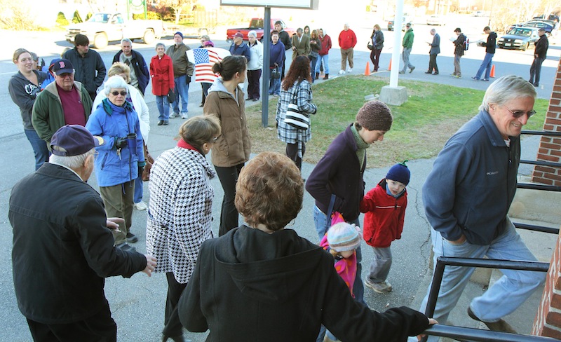 Photo by Jeff Pouland LINING UP TO VOTE: A long line of voters extends out the door of the Bourque-Lanigan American Legion Post 5 shortly after the polls opened in Waterville on Tuesday. High voter turn out is expected today.