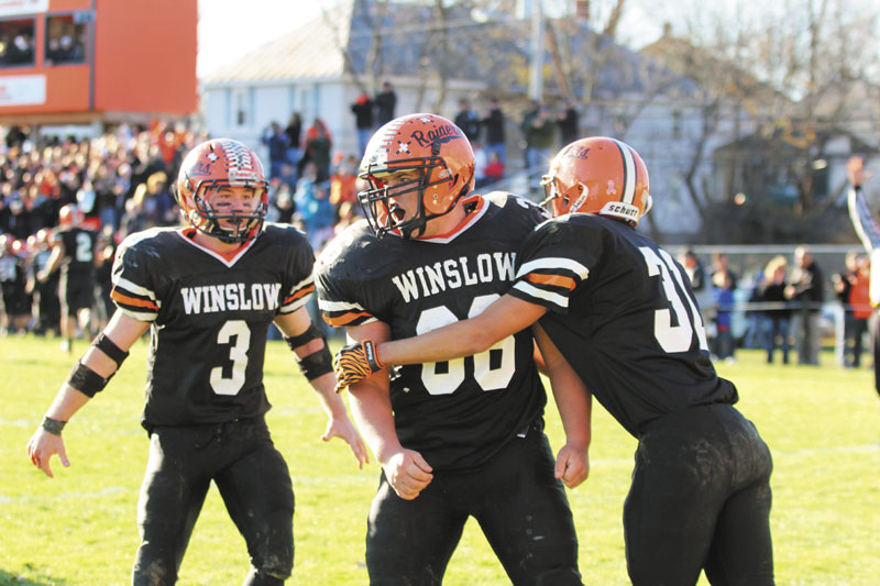 SCORING A REACTION: Winslow High School's Zachary Guptill, center, is congratulated by teammates Ricky Crayton, right, and Dylan Hapwort (3) after scoring a second-half touchdown during the Black Raiders' 17-6 win over Dirigo High School in the Western Maine Class C final on Saturday in Winslow.