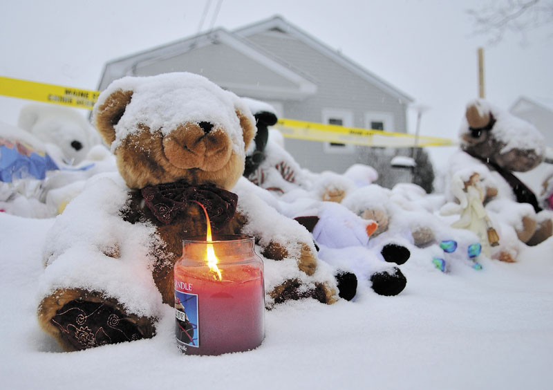 A candle illuminates a growing teddy bear shrine for missing girl Ayla Reynolds outside her home in Waterville on Dec. 25, 2011.