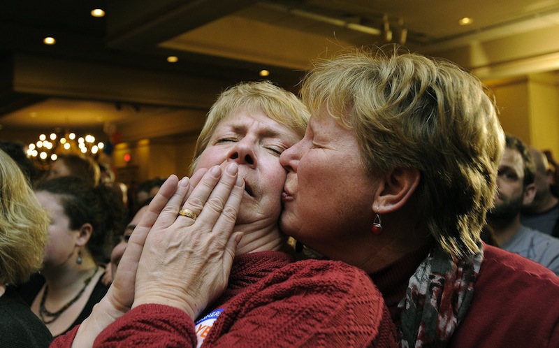 Ellie MacCallum, left, of Windham, receives a kiss from her partner, Judy Eycleshymer, right, after they learned same sex marriage had passed while at the Mainers United for Marriage party at the Holiday Inn by the Bay Tuesday, November 6, 2012. Marriage licenses for same-sex couples in Maine will be issued beginning Dec. 29.