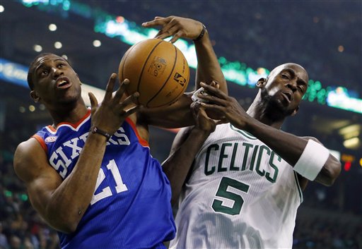 Philadelphia 76ers' Thaddeus Young (21) and Boston Celtics' Kevin Garnett (5) vie for a rebound in the first quarter of an NBA basketball game in Boston, Saturday, Dec. 8, 2012. (AP Photo/Michael Dwyer)
