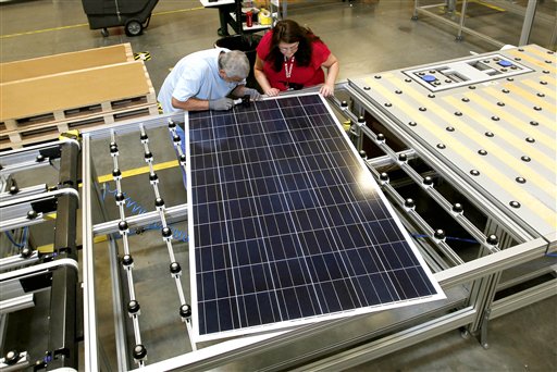 Stacey Rassas, right, a quality control manager at a Suntech Power Holdings Co., a Chinese-owned solar panel manufacturer, examines a solar panel with her co-worker Frank Garcia at a company facility in Goodyear, Ariz., recently. The factory makes solar panels for one of the world's biggest solar manufacturers.