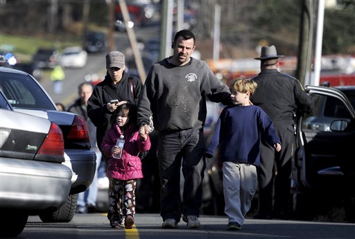 Parents leave a staging area after being reunited with their children following a shooting at the Sandy Hook Elementary School in Newtown, Conn., on Friday.
