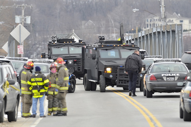 Swat teams appear at the scene of a fire in Webster, N.Y., Monday, Dec. 24, 2012. Police in New York state say a man who killed two firefighters in a Christmas Eve ambush had served 17 years for manslaughter in the death of his grandmother. (AP Photo/Messenger Post Media, Seth Binnix)