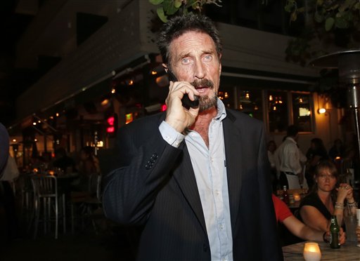 Anti-virus software founder John McAfee talks on his mobile phone as he walks on Ocean Drive in the South Beach area of Miami Beach, Fla., on his way to dinner Wednesday.
