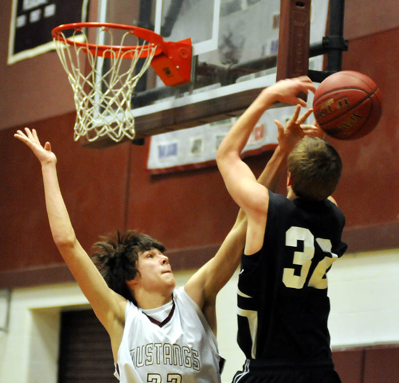 Hall-Dale High School’s Nic Caron has his shot blocked by Monmouth Academy’s Nick Tozier during the Mustangs’ 32-25 win Wednesday in Monmouth. For the high school roundups, see C3.