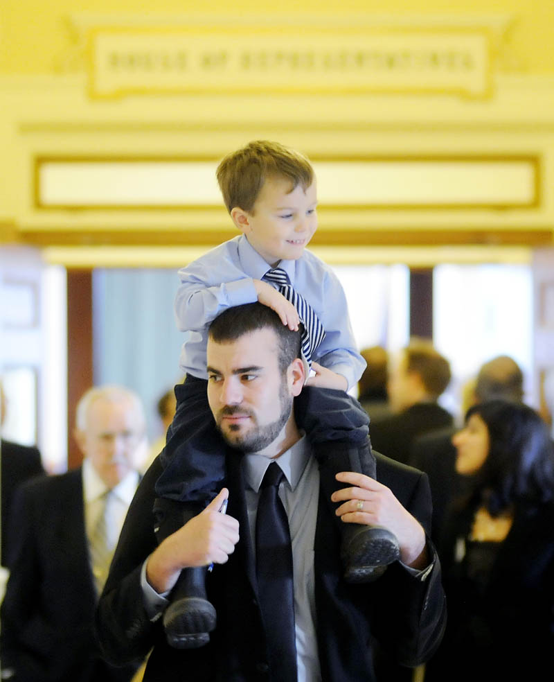 Rep. Jeff McCabe, D-Skowhegan, carries his son, Finnegan, 4, Wednesday, Dec. 5, before being sworn in for a new term in the House of Representatives at the State House in Augusta.