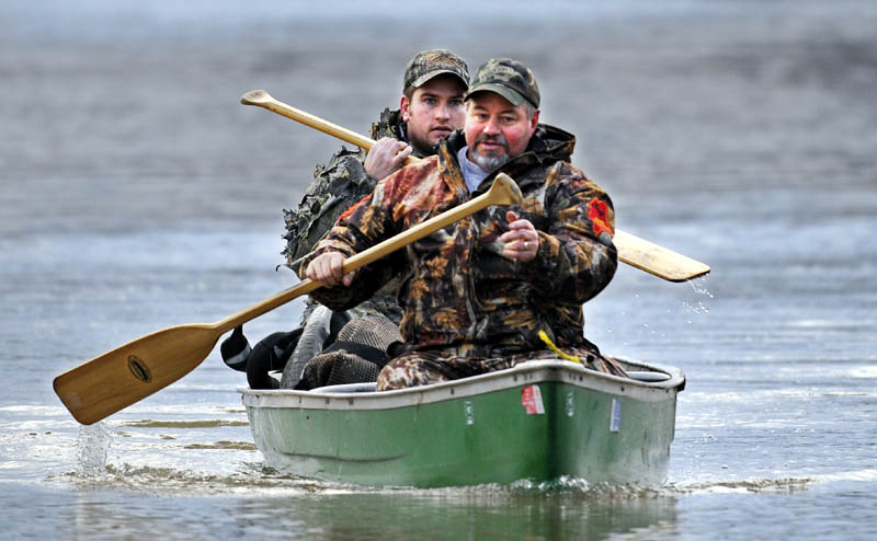 Steve Swindells, right, of Smithfield and his son, Matt of Gardiner, return to their blind in Chelsea on Saturday, while waterfowl hunting at dawn on the Kennebec River. The men said they spotted flights of ducks and geese but didn't harvest any birds.