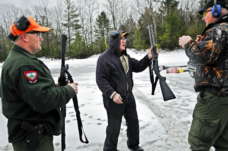 Deputy Game Warden Don Gray, center, hands a shotgun to District Game Warden Norman Lewis, right, as he and acting Sgt. Dave Chabot, left, prepare to fire the weapons Wednesday at a range in Augusta. The state wilderness law enforcement officers qualify on sidearms and shotguns twice a year. Gray, who retired from the warden service as a sergeant after four decades of service, still serves as a deputy warden in the Bethel area.