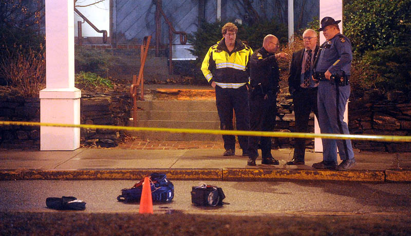 Staff photo by Michael G. Seamans Police investigate the scene where a man was shot on The Concourse late Tuesday night in Waterville.