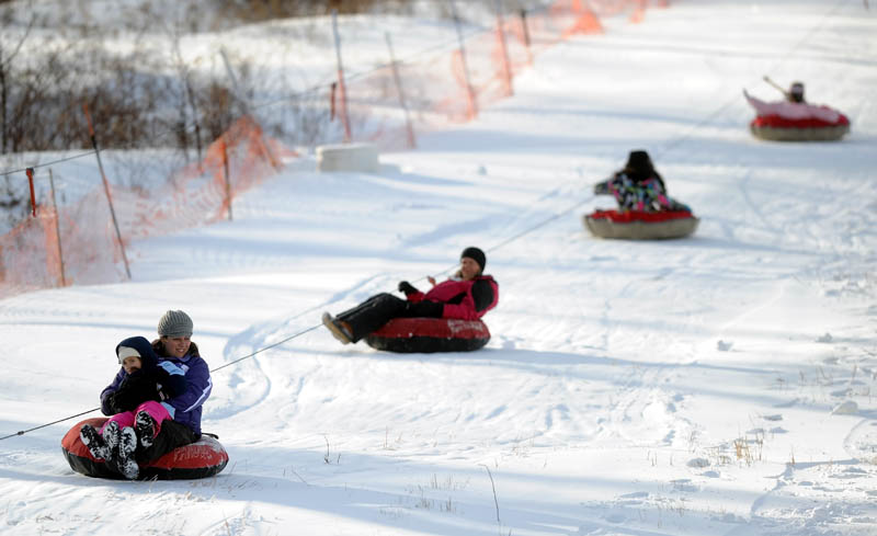 Tubing enthusiasts ride the rope tow to the top of the slope at Eaton Mountain Ski Area in Skowhegan on Friday. Snow tubing opened Friday for the season.