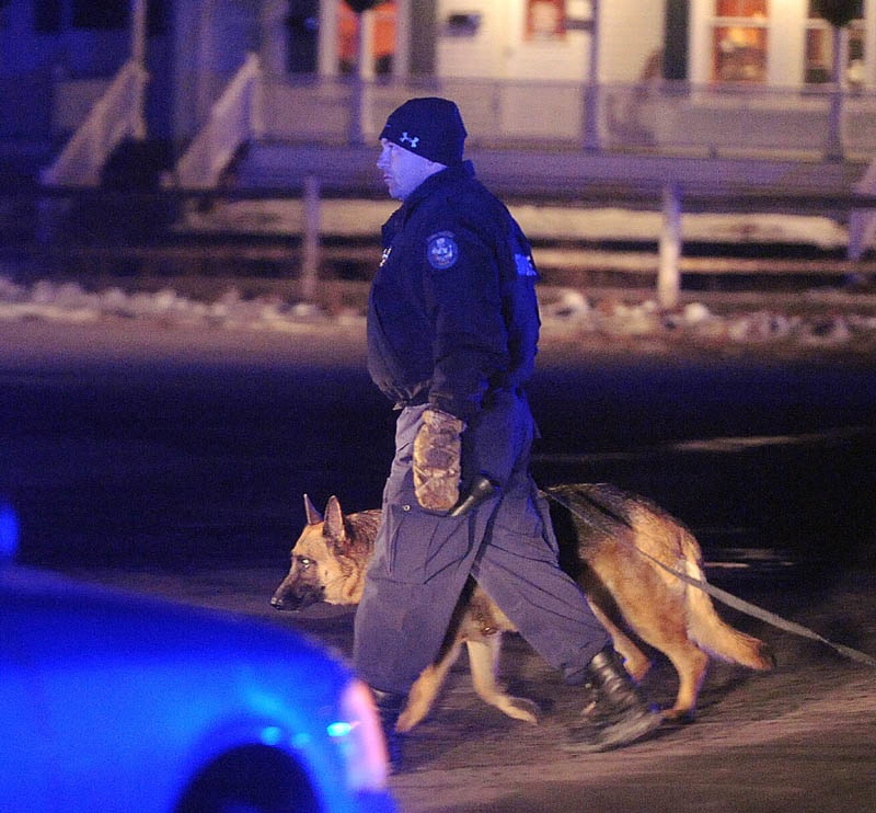 State police Trooper Rick Moody and his dog, Kushel,search for a man who robbed the Franklin Savings Bank in Skowhegan Thursday night.