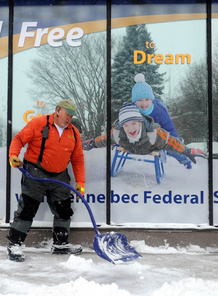 Bruce Heath, owner of KB Property Care, clears the sidewalk in front of Kennebec Federal Savings Bank on Main Street in downtown Waterville on Thursday.